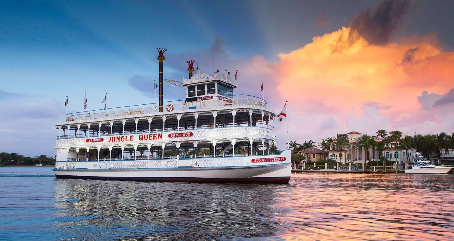 A large white riverboat named Jungle Queen on calm waters during sunset. Junglequeen Ignite The Night Isle Dinner Show With S Dinner Cruise Jungle Queen Sunset