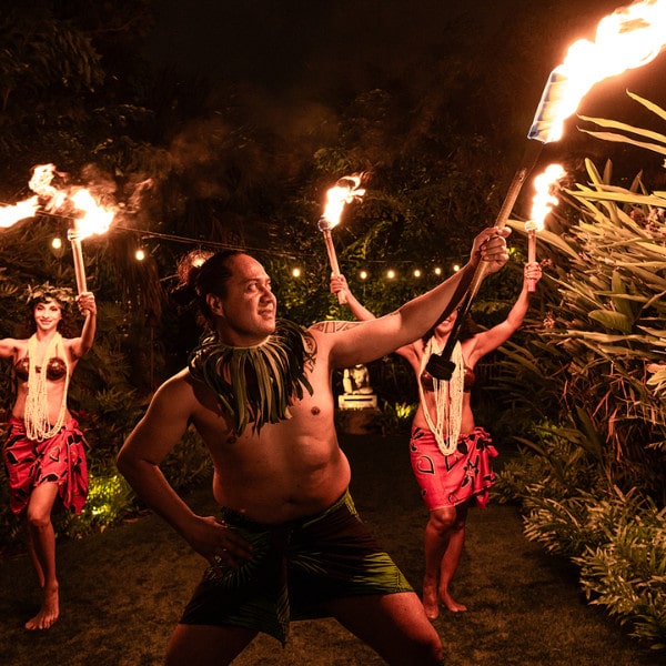 Performers with torches dance in a lush garden at night. Junglequeen Ignite The Night Isle Dinner Show With S Fire Dancers Night Performance
