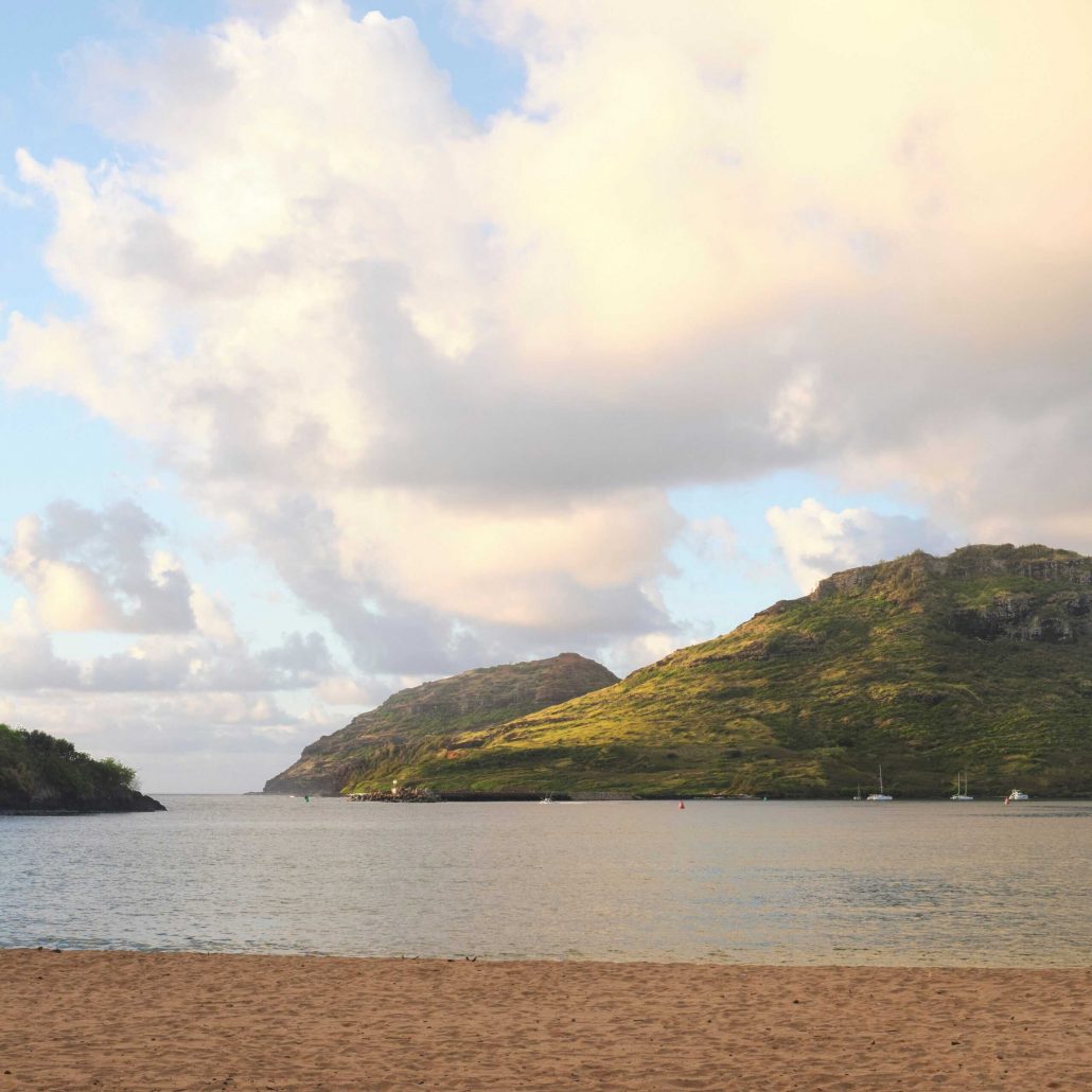 A sandy beach with mountains and clouds reflected in the water. Royalsonestaluau Drums Dances Of Polynesia At The Royal S Beach Mountains Clouds Water