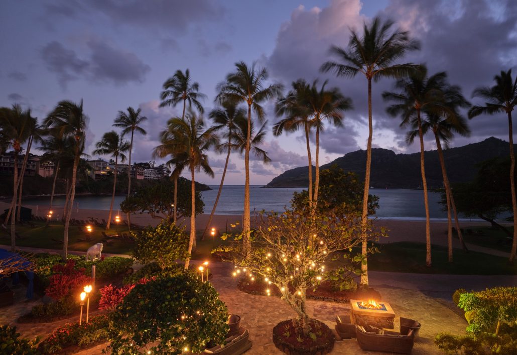 Palm trees stand near a beach with glowing lights and a sunset sky. Royalsonestaluau Drums Dances Of Polynesia At The Royal S Palm Trees Beach Sunset Lights