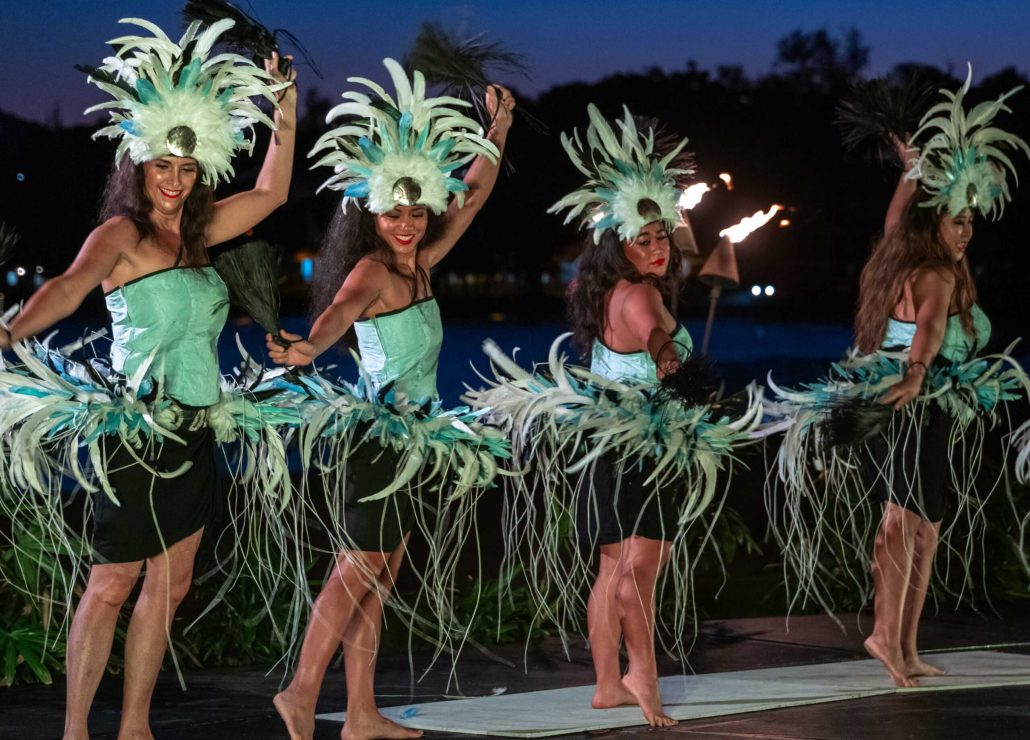 Four dancers in feathered costumes perform with tropical backgrounds. Royalsonestaluau Drums Dances Of Polynesia At The Royal S Polynesian Dancers Feather Costumes