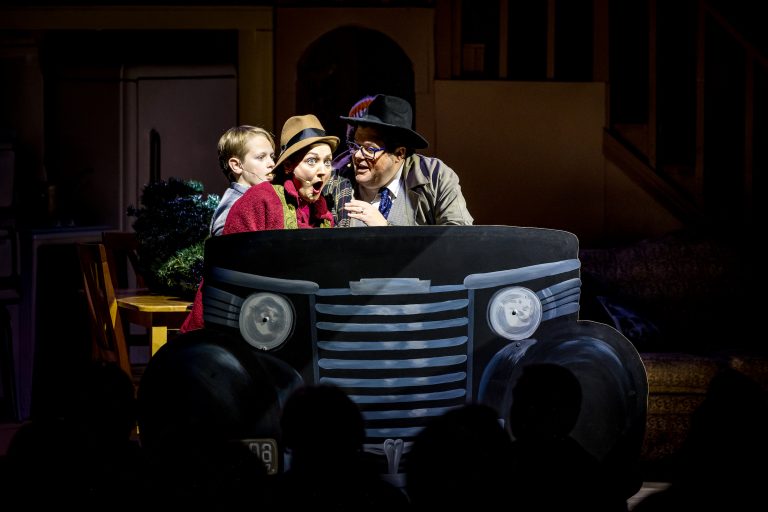Three performers act surprised while sitting in a painted car. Theshepherdofthehills A Christmas Story Dinner Show Dinner Show Theater Performance Car
