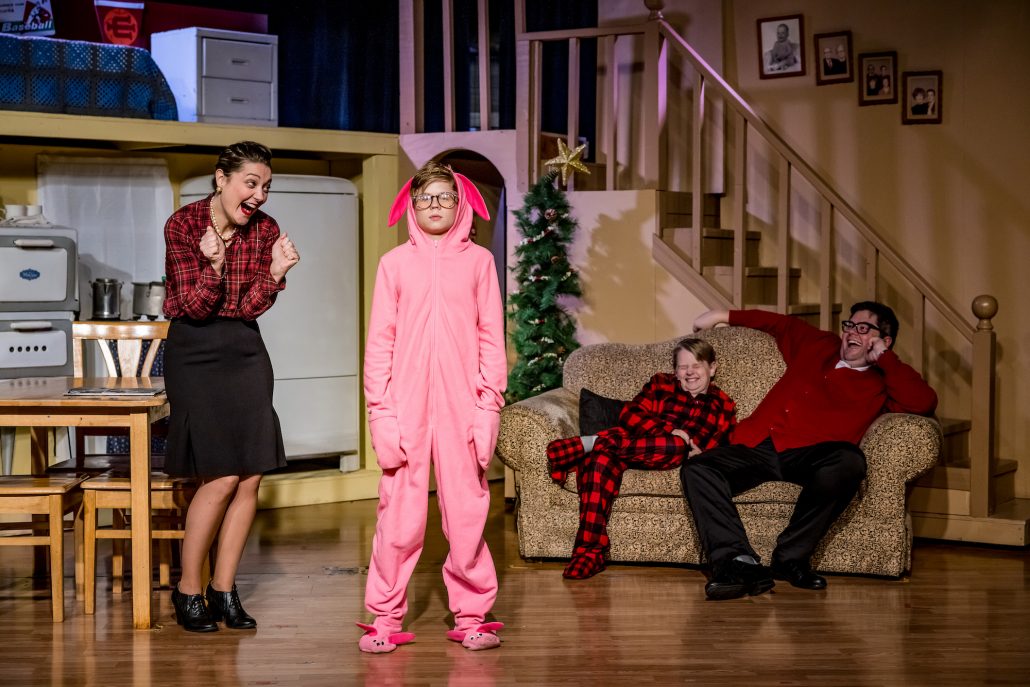 A girl in a plaid shirt excitedly reacts to a boy in a pink bunny suit. Theshepherdofthehills A Christmas Story Dinner Show Dinner Show Theater Performance Costumes