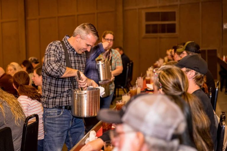 A man in a plaid shirt serves food while guests enjoy their meals. Theshepherdofthehills Branson S Whodunnit Hoedown Murder Myste Dinner Show Mystery Actors Audien