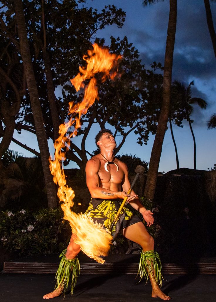 A fire dancer performs with flames swirling around him at dusk. Westinmaui Ohana Seating Fire Dancer Luau Performance