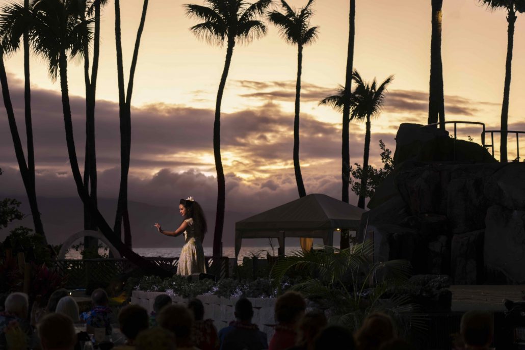 A hula dancer performs at sunset with palm trees in the background. Westinmaui Ohana Seating Hula Dancer Sunset Palm Trees