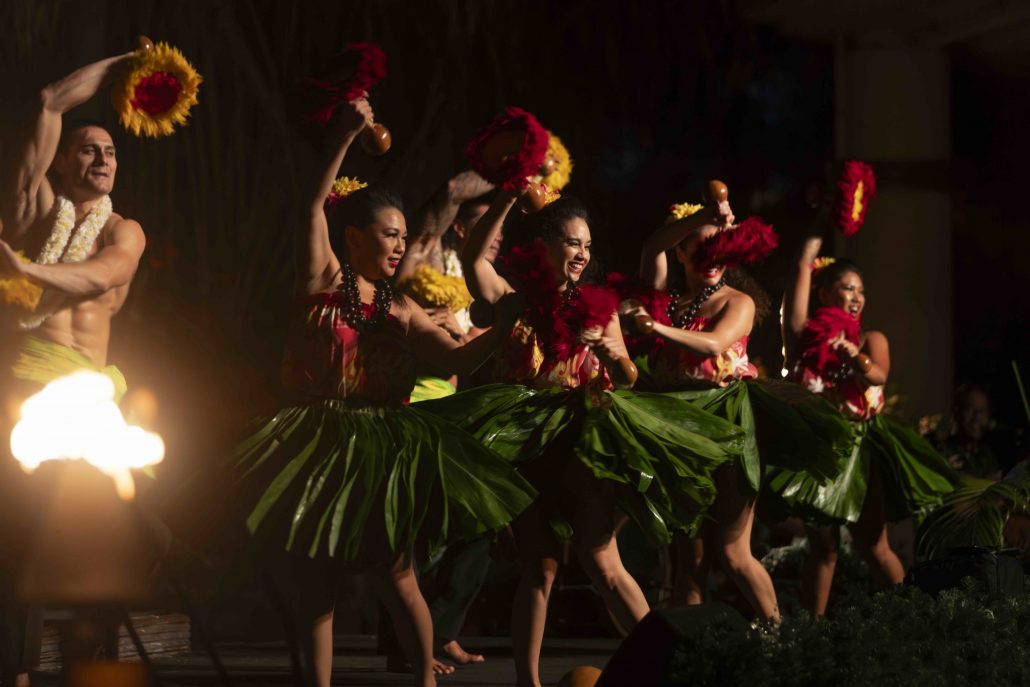 Dancers in traditional attire perform hula with vibrant skirts and props. Westinmaui Ohana Seating Luau Dancers Hula Performance