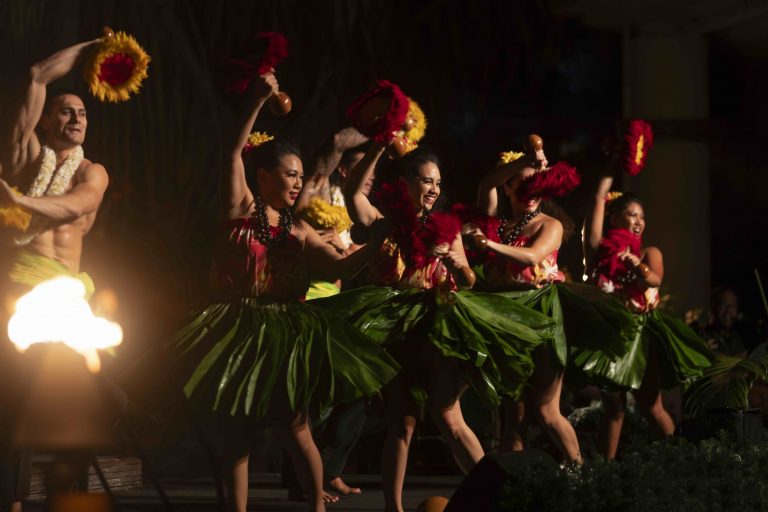 Dancers in traditional attire perform hula with vibrant skirts and props. Westinmaui Ohana Seating Luau Dancers Hula Performance